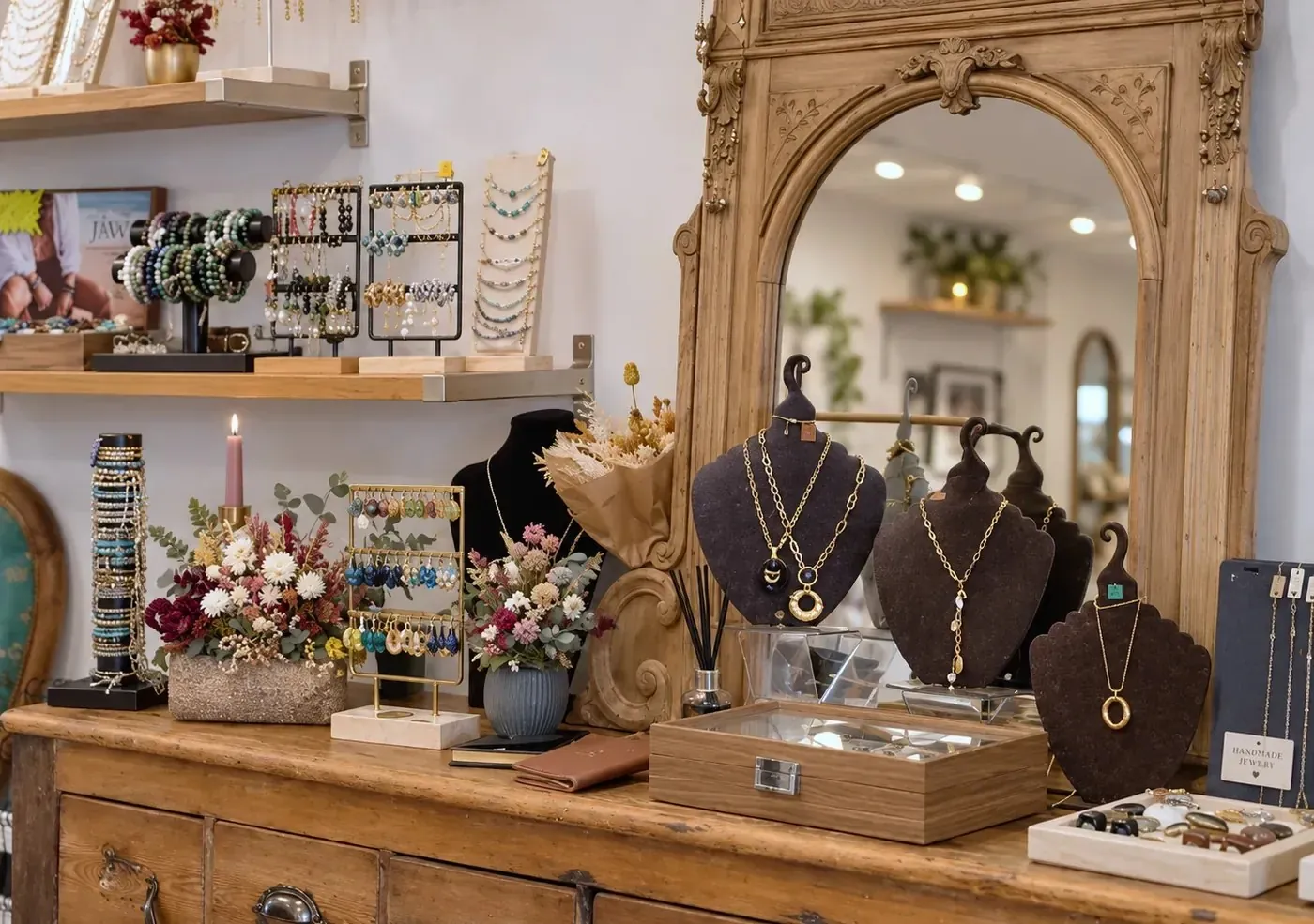 Présentoirs de colliers et bijoux devant un miroir doré dans une boutique de mode